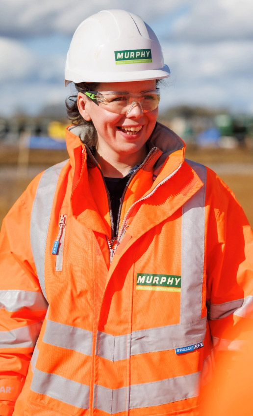 A Murphy colleague smiling outdoors, wearing a high-visibility coat and PPE.