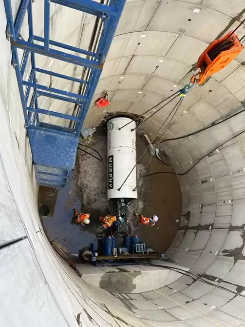 People wearing safety uniform inside of a concrete cylinder at a onshore cable civils works.