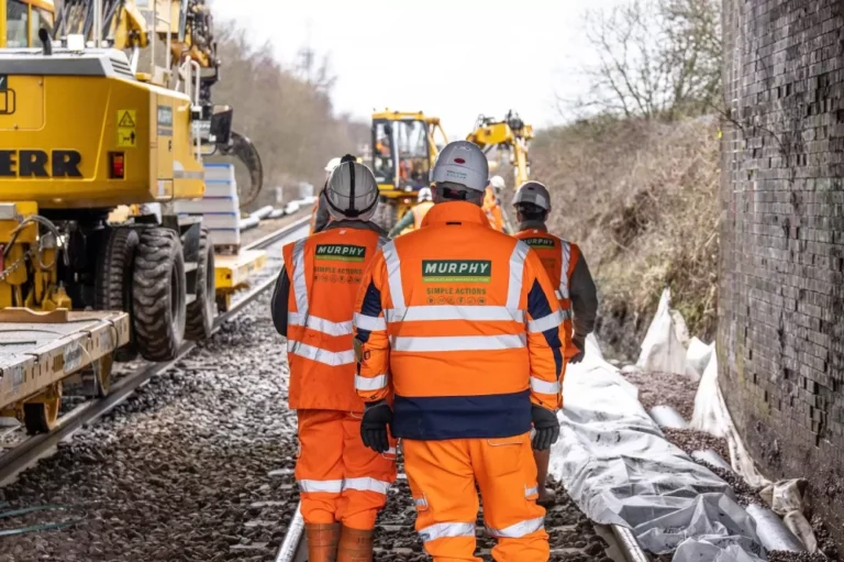 Murphy employees in safety uniform working on a train track construction site.
