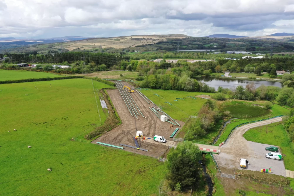 An aerial view of the countryside with a construction site next to a river.