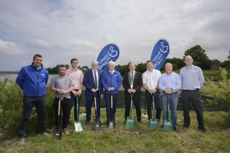 A group of people in the countryside holding green shovels with the Murphy logo.