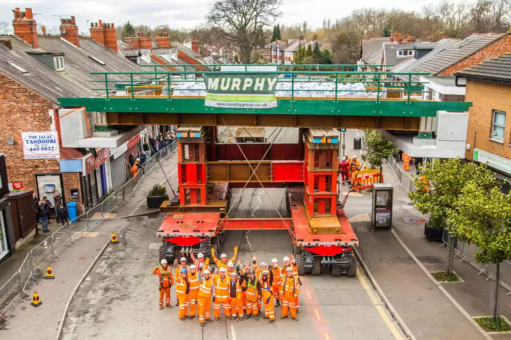 A group of Murphy employees stood in the road in front of a Murphy branded transportation vehicle.