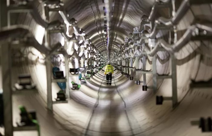 A person in safety uniform stood inside a power tunnel.