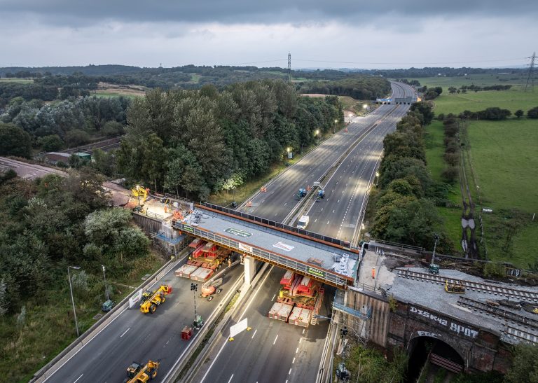 An aerial view of a bridge installation over a motorway.