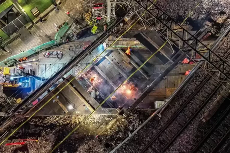 A bridge replacement construction site from above next to some train tracks.