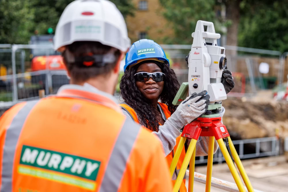 Two staff members wearing Murphy uniform and operating a camera on a construction site.