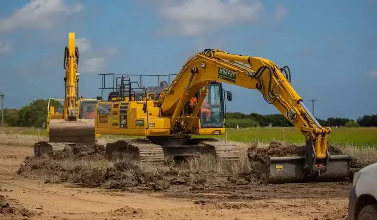 A Murphy branded construction vehicle digging up a field.