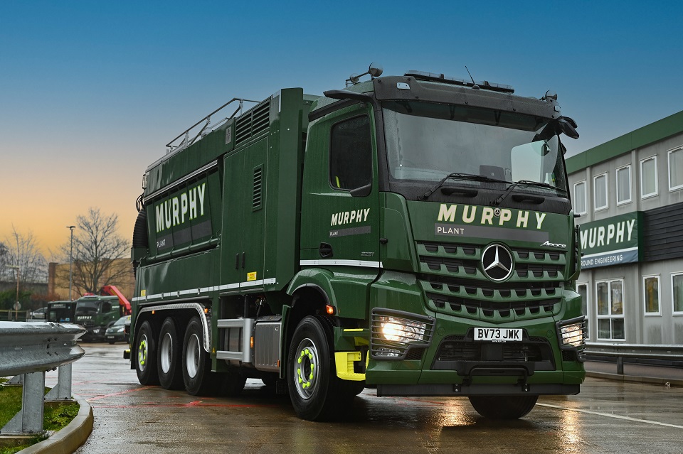 Large Murphy heavy goods vehicle driving on road outside building with a Murphy sign.