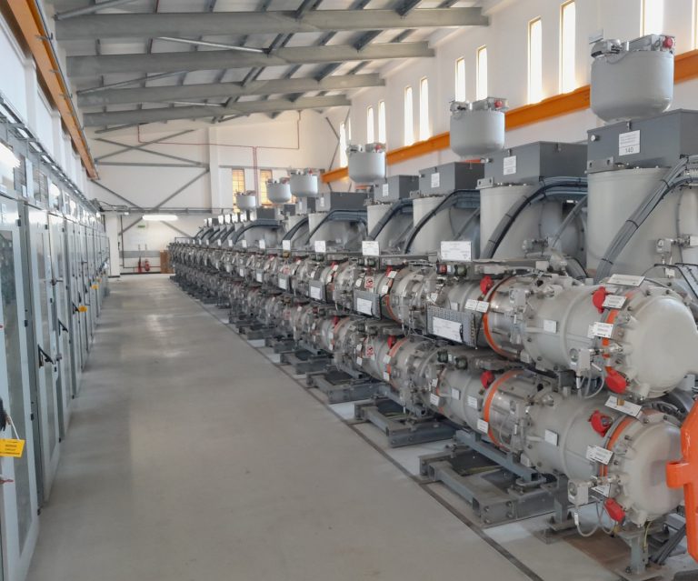 The interior of an energy substation showing machinery in a brightly lit room.