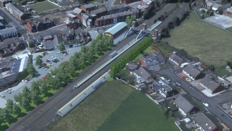 A graphic of an aerial view of a train station surrounded by houses and fields.