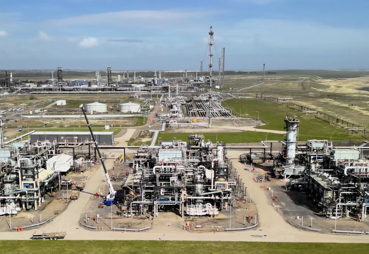 An combustion plant site surrounded by fields in the daytime.