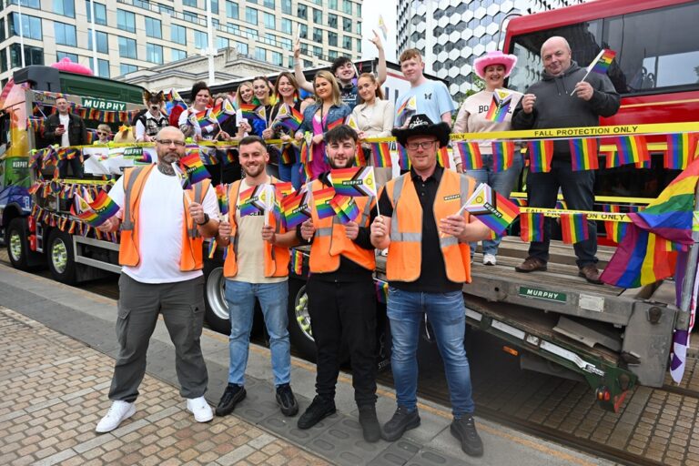 A group of Murphy employees at a Pride event holding LGBTQ+ flags.