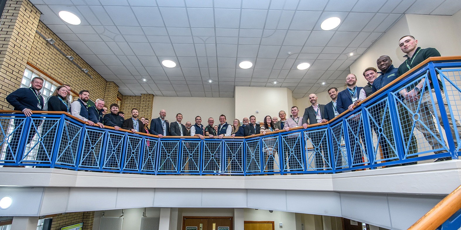 A group of Murphy employees stood around a blue balcony posing for a photo.
