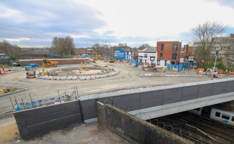 The Greek Street roundabout under construction on a bridge with train tracks underneath.